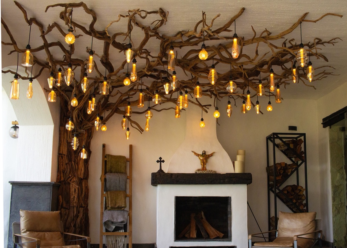 Salón con chimenea blanca y ramas iluminadas