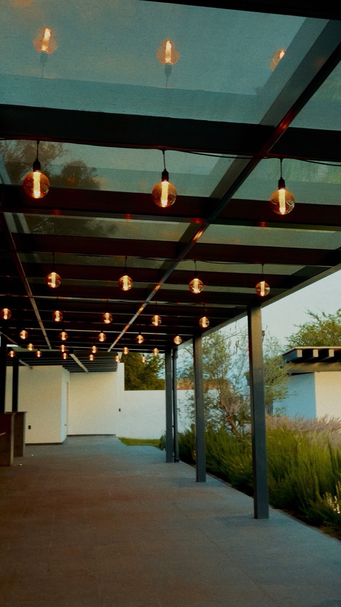 Terraza con focos colgantes junto al jardín