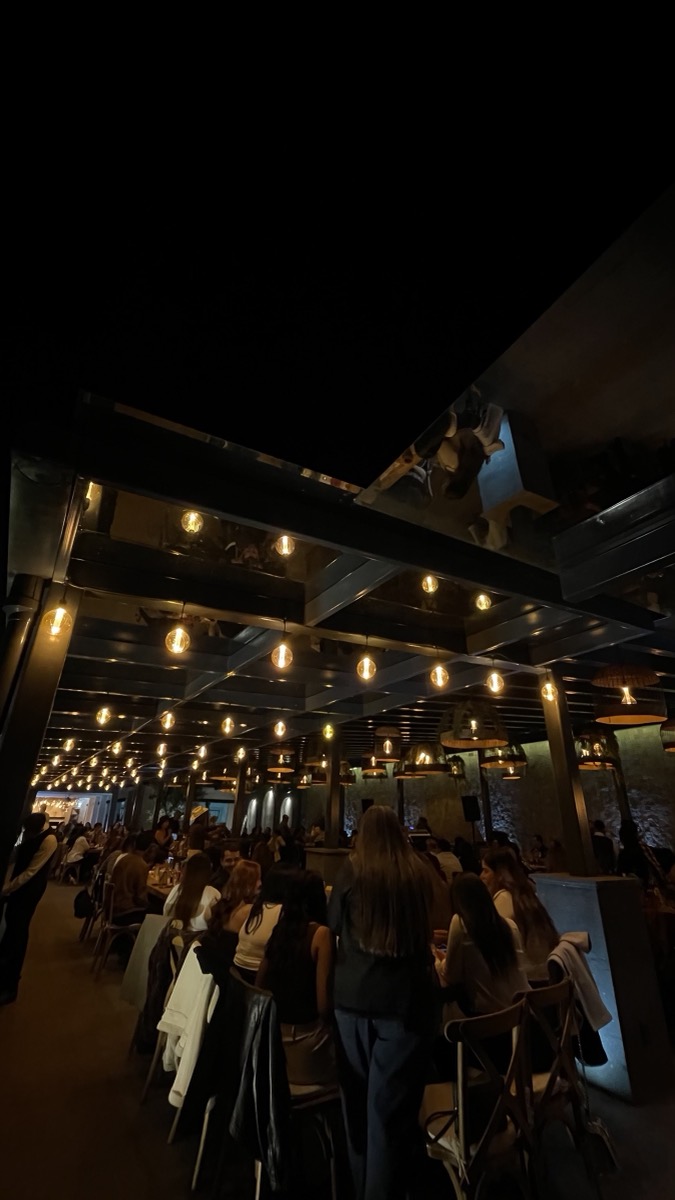 Terraza llena de invitados bajo los focos